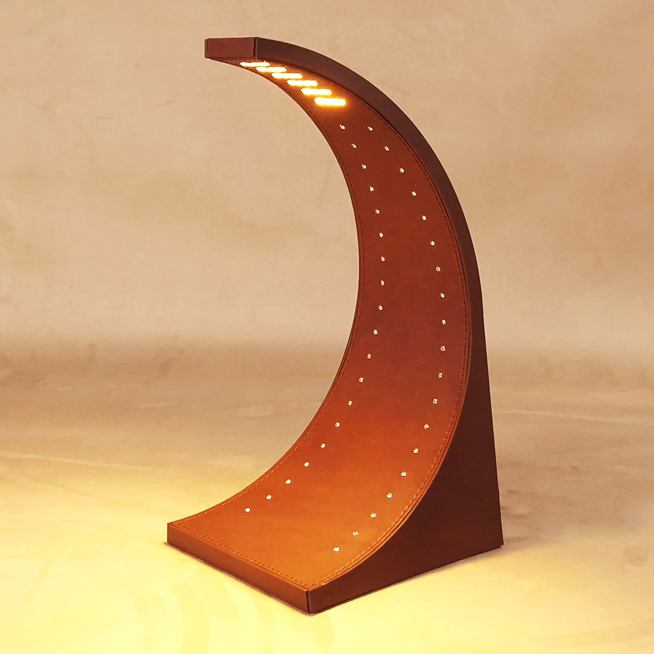 Lampada da tavolo OXI by ZULPO, con struttura curva rivestita in cuoio cognac, illuminazione LED e cristalli Swarovski
